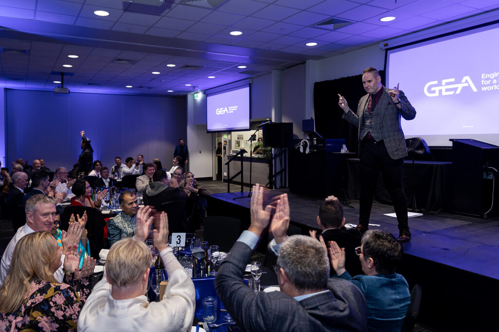 Brendan Dooley on stage with audience clapping