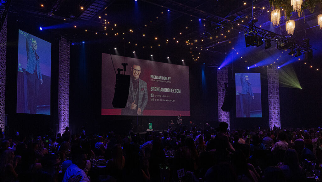 Brendan Dooley Comedy Magician on stage with audience in Wellington at a gala at TSB Arena