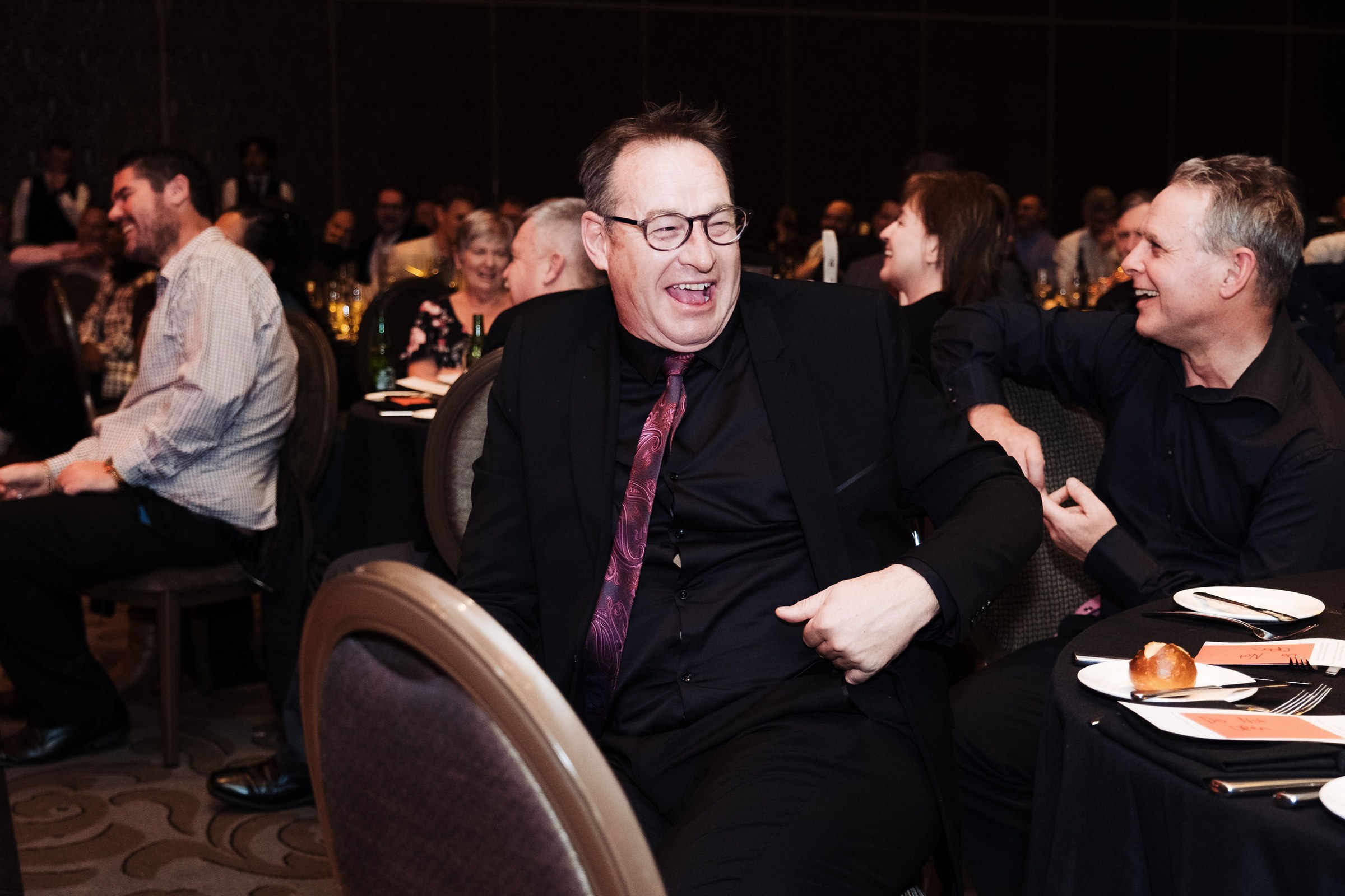 Guests laughing during entertainment at an end of year function